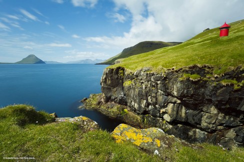 Stunning coastal scenery and a lighthouse with Koltur Island in the background, located in the picturesque village of Velbastadur.