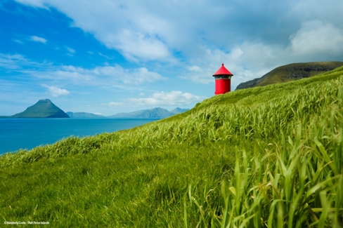 Stunning coastal scenery and a lighthouse with Koltur Island in the background, located in the picturesque village of Velbastadur.